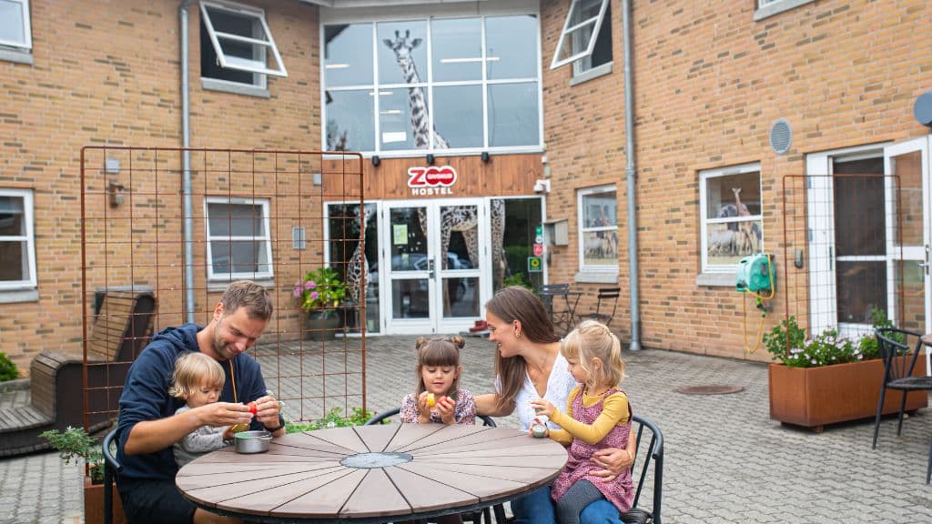 Gäste versammelt am Gartentisch im GIVSKUD ZOO HOSTEL